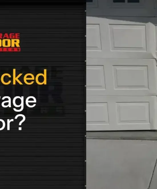 White raised-panel garage door with a buckled, creased panel above the driveway