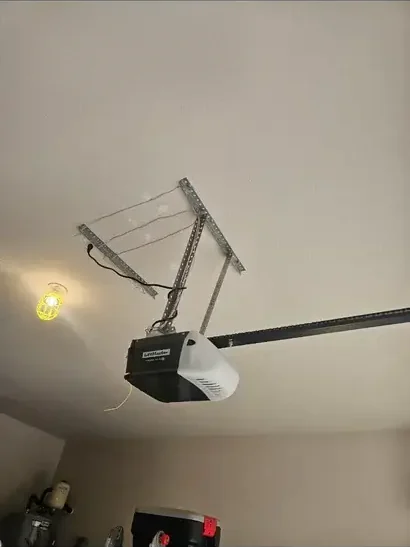 LiftMaster garage door opener installed on a garage ceiling with angle-iron mounting brackets